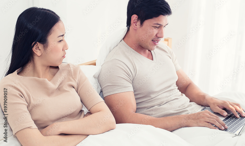 worried woman lying next to her, trying to peek at screen. Cheating and infidelity concept worried woman lying next to her, trying to peek at screen. Cheating and infidelity concept