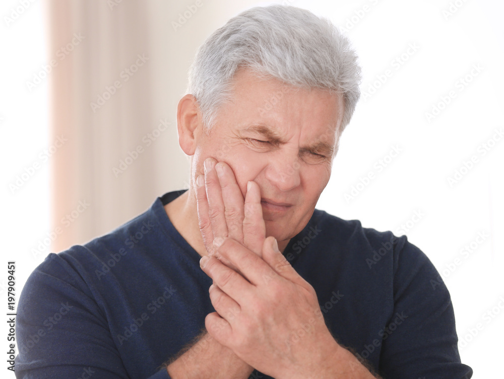 Mature man suffering from toothache at home Mature man suffering from toothache at home