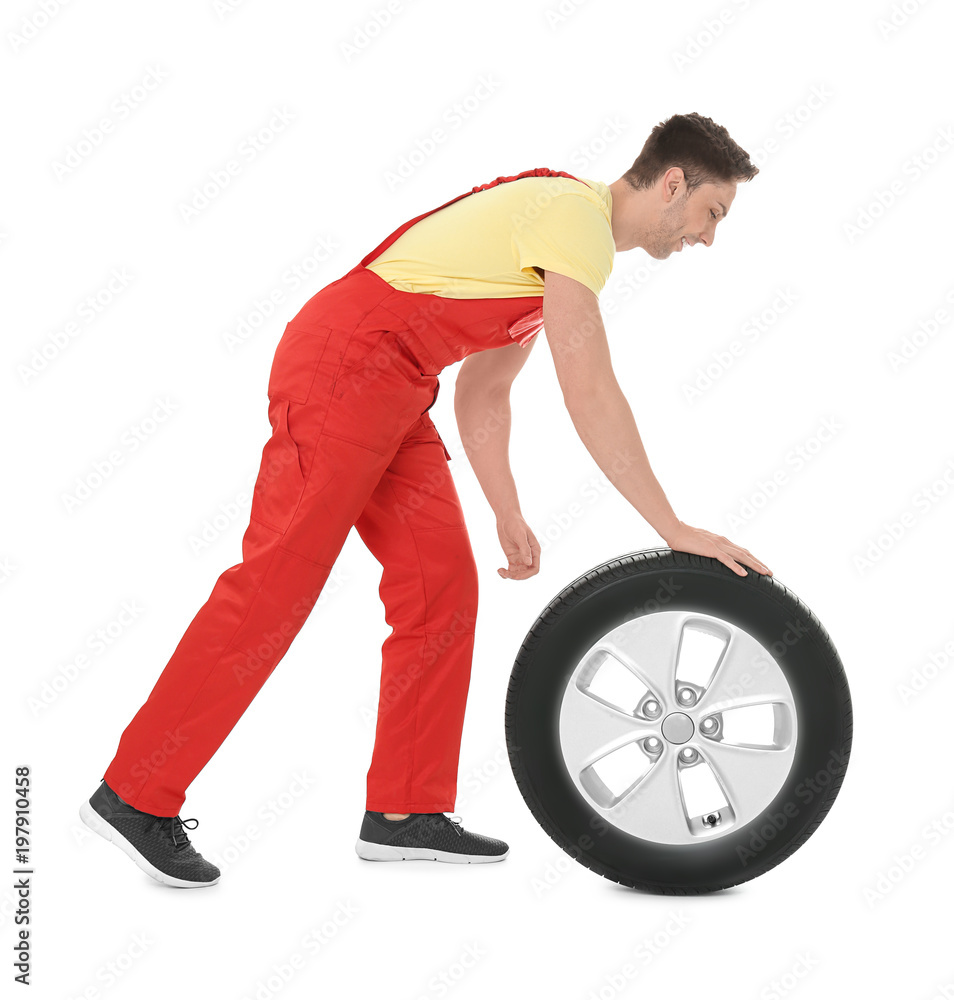 Young mechanic in uniform with car tire on white background Young mechanic in uniform with car tire on white background