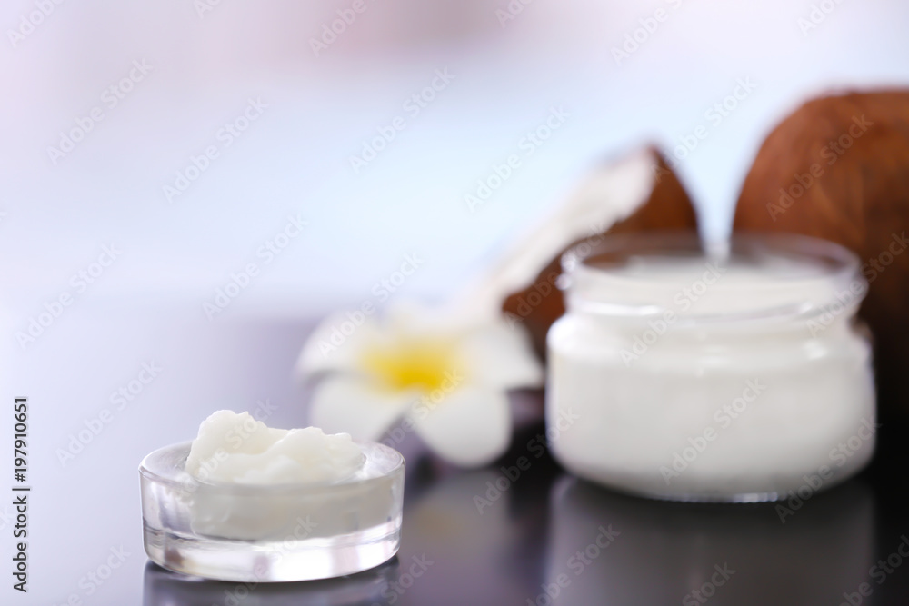 Composition with coconut butter in glass jar on blurred background Composition with coconut butter in glass jar on blurred background