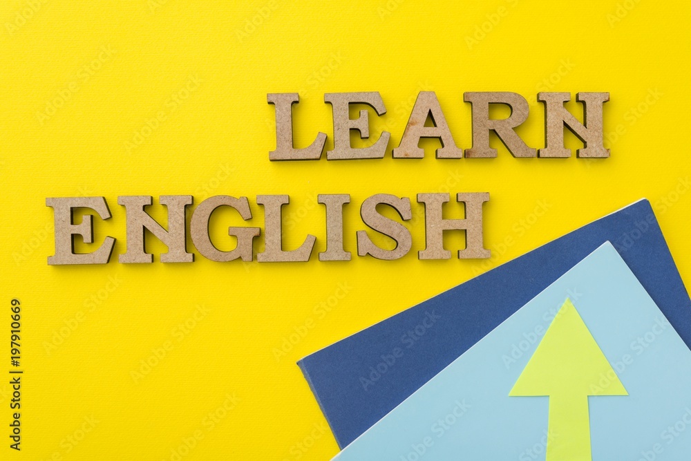 Fototapeta premium Learn English, words in wooden letters with yellow background