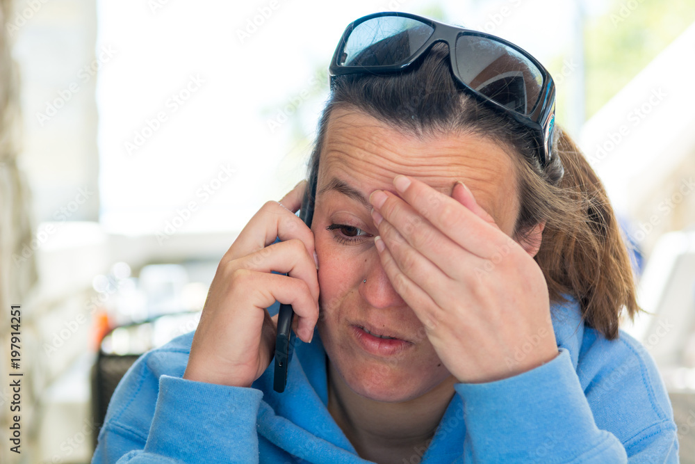 Attractive brunette taking a phone call in outdoor restaurant. Attractive brunette taking a phone call in outdoor restaurant.