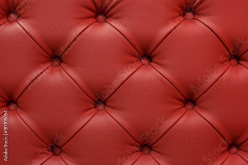 Dark red leather sofa stitched buttons.