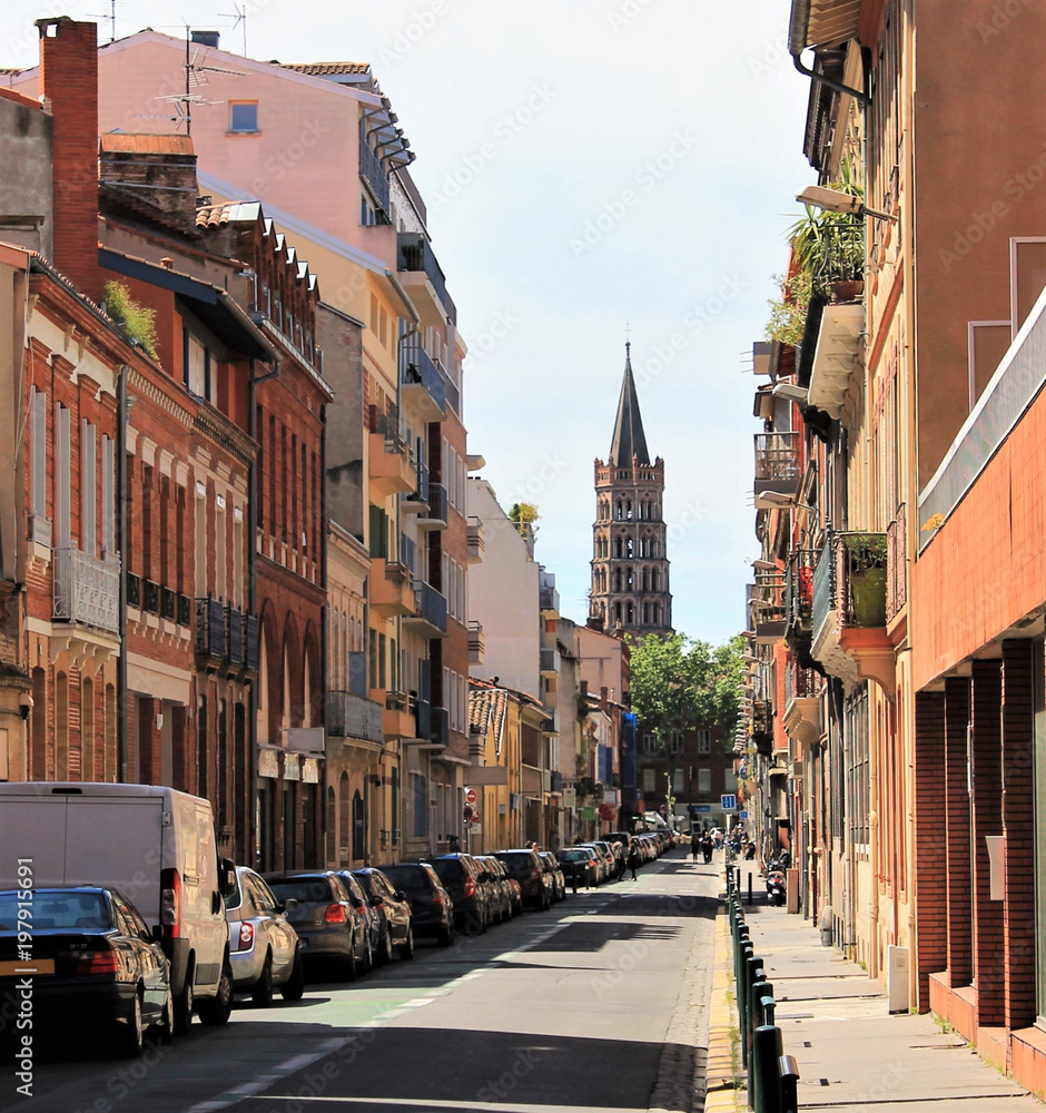 View of Saint Sernin basilica from a typical colorful street of Toulouse, Haute Garonne, Occitanie region, France