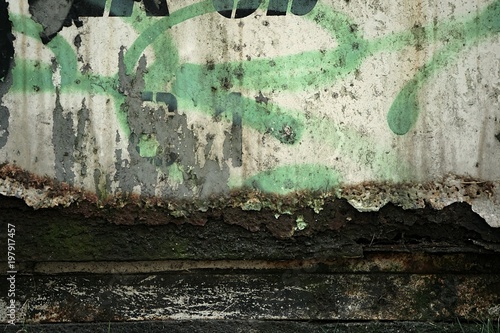 A wall with painted graffiti and rust photo