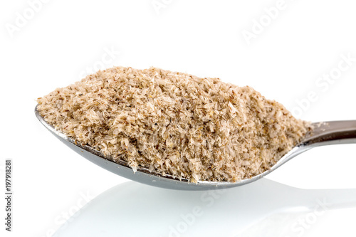 Medicinal Isabgol, ispaghula or psyllium husks on a stainless steel spoon isolated on white background with shadow reflection. Psyllium seed coat on a scoop on white backdrop. photo