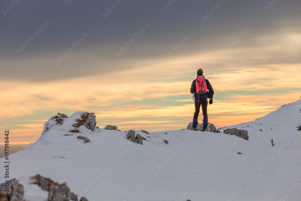 Alpinist on a snow covered crest at sunset, Col Visentin, Belluno, Italy