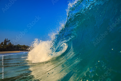Surfing wave in blue ocean water background