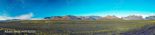 Panoramic photography of Vatnajokull national park with three glaciers and green grass in foreground © LeeSensei