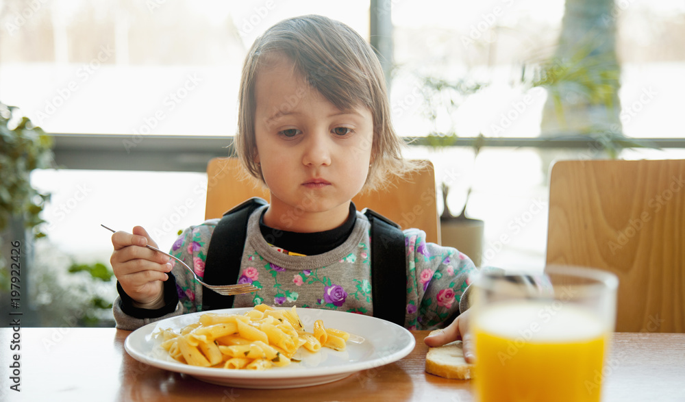 Little cute child girl with fork eating noodles (Tasty food concept) Little cute child girl with fork eating noodles (Tasty food concept)