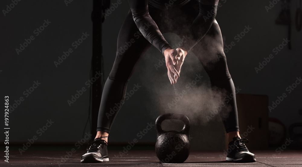 Athletic young man working out in gym. Muscular male adult exercising with kettle bells, functional or cross training. Fitness and sports concept. - obrazy, fototapety, plakaty 