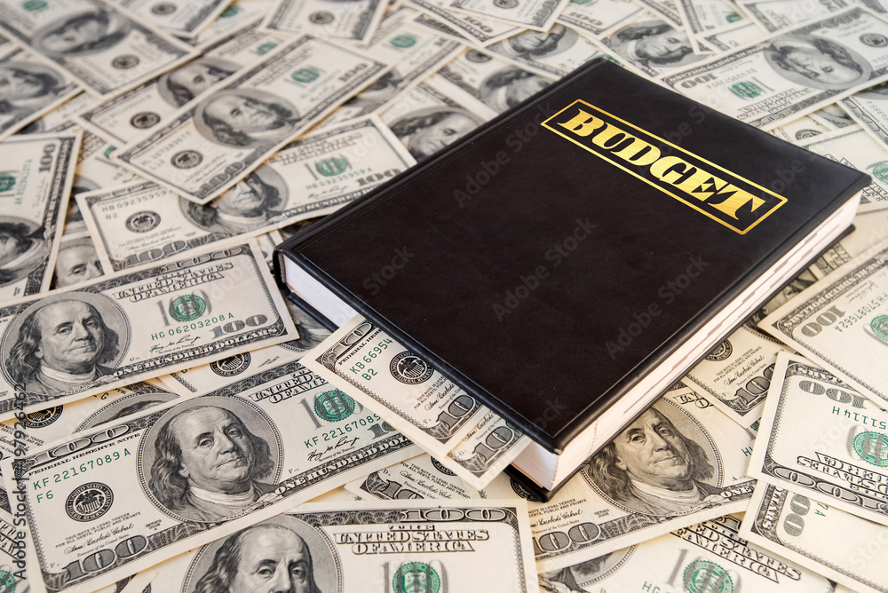 Black book with money and the inscription budget on dollar banknotes background Black book with money and the inscription budget on dollar banknotes background