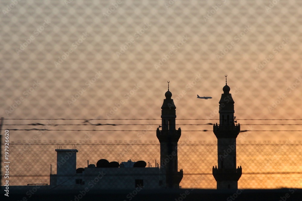Fototapeta premium Red sunset with sun and silhouette of mosque minaret