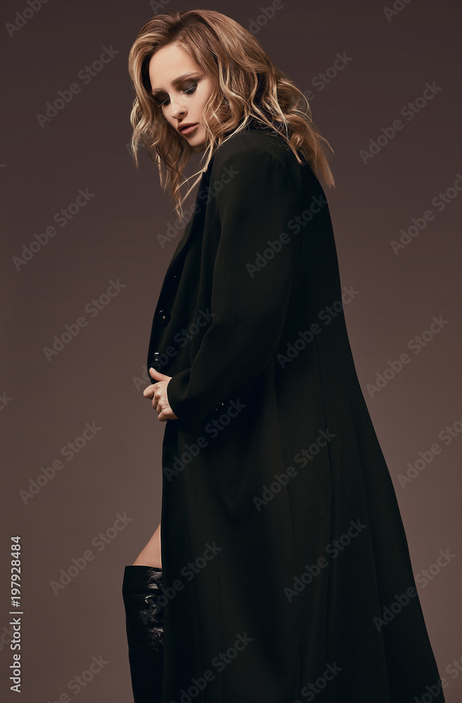 Sexy seductive blonde girl in underwear and black coat