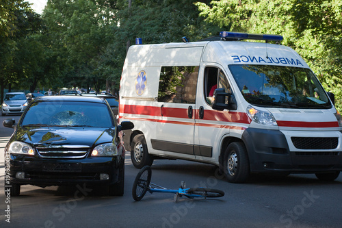 accident on the road. The car knocked the bicyclist. The ambulance takes away the victims.