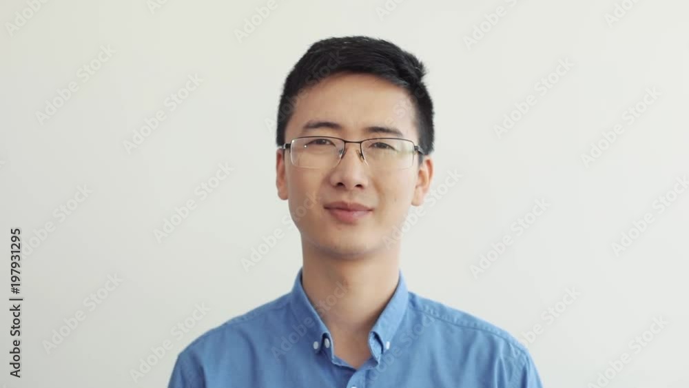 Close up face asian businessman with glasses look at camera smile portrait office suits blue shirt wearing working business adult arms cute slow motion self-employed street success executive serious Close up face asian businessman with glasses look at camera smile portrait office suits blue shirt wearing working business adult arms cute slow motion self-employed street success executive serious