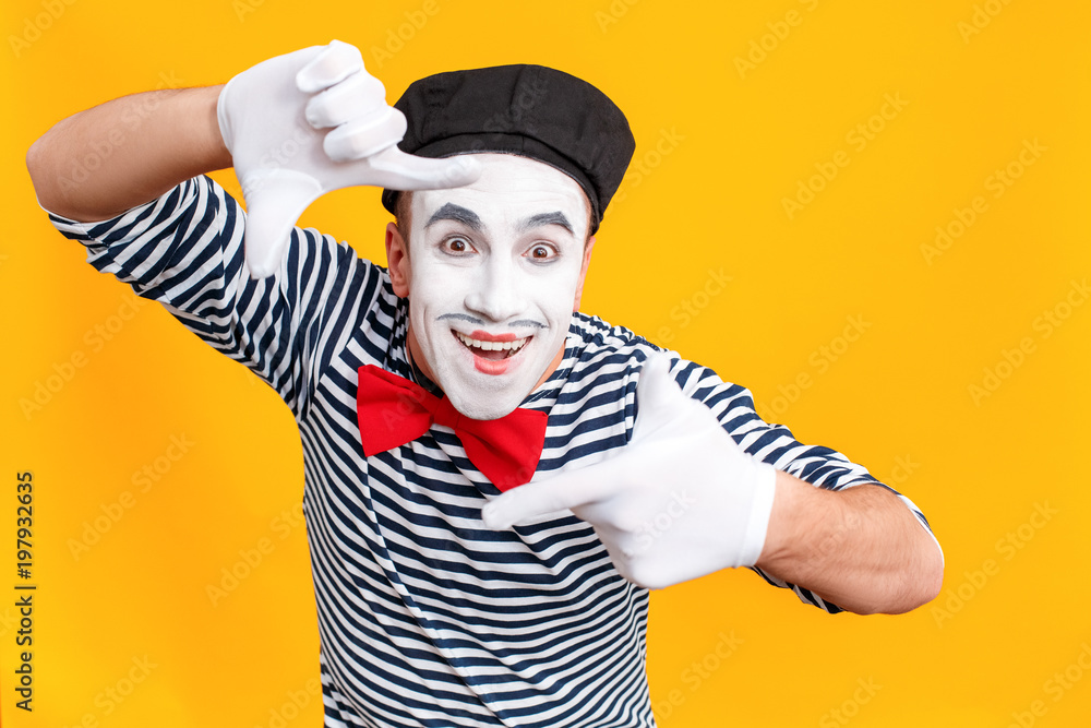 Toothy smiling mime man making fingers frame Toothy smiling mime man making fingers frame