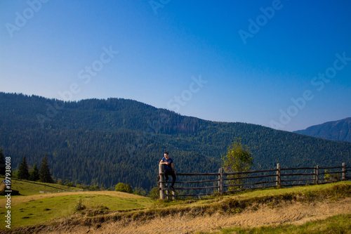 Tourist man on top of mountains with blue sky. Man enjoying free happiness in beautiful landscape. Travel concept © Svetlana