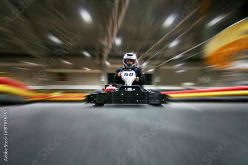The man is in the go-kart on the karting track photo