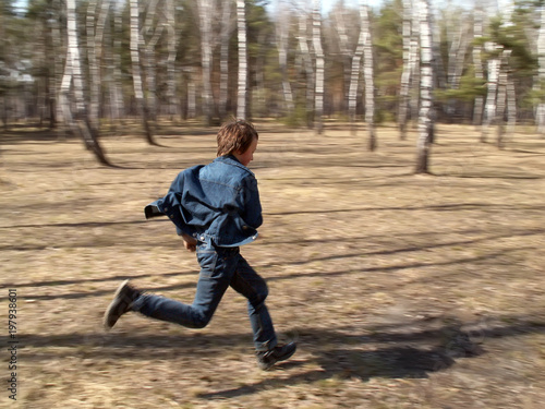 The boy is running in the forest