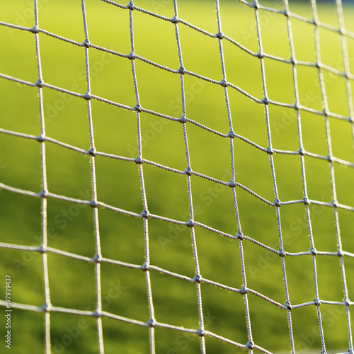 Soccer net on green live, on background of green grass close-up
