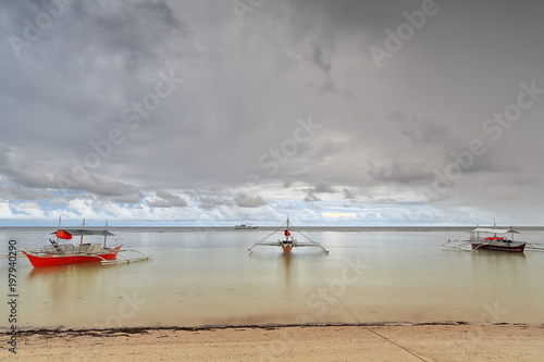 Sunset over stranded balangay or bangka boats. Punta Ballo beach-Sipalay-Philippines.0350 photo