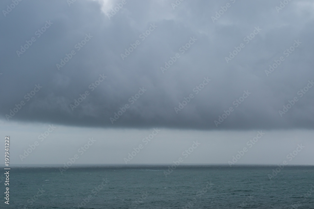 Amazing water landscape with heavy wall clouds over the ocean surface