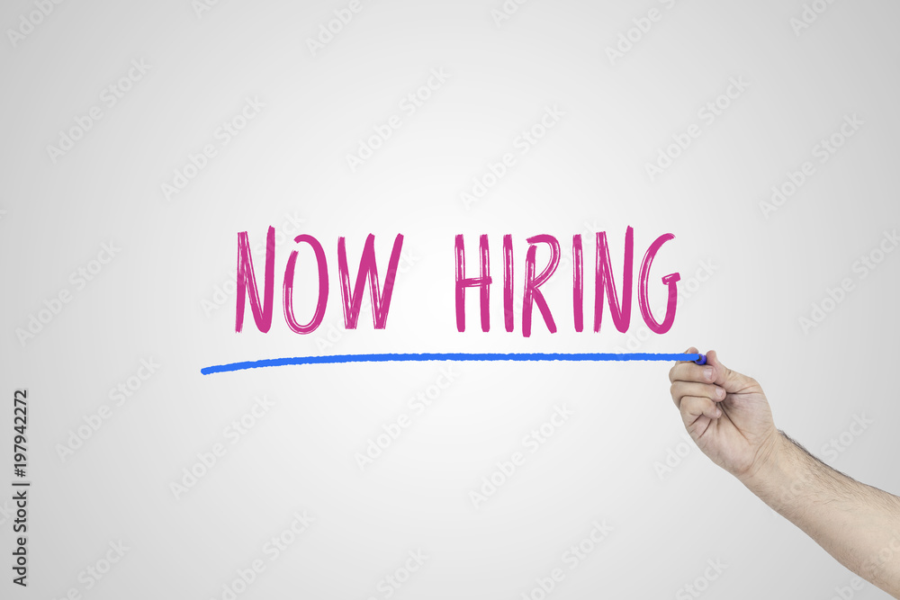 Fototapeta premium Human's hand writing Now hiring on whiteboard.