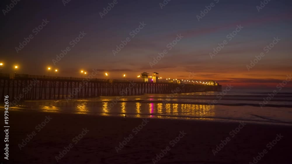 California Oceanside pier at sunset with reflections on wet beach sand California Oceanside pier at sunset with reflections on wet beach sand