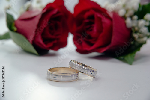 Wedding rings and red roses.