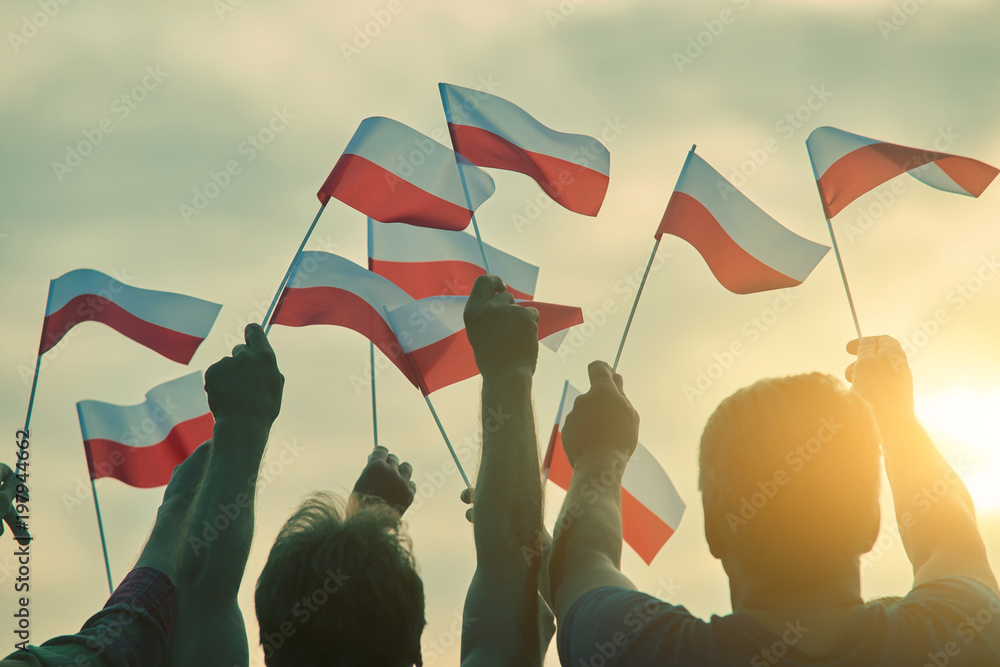 Poland patriots, back view. People raising polish flags up to the sky. - obrazy, fototapety, plakaty 