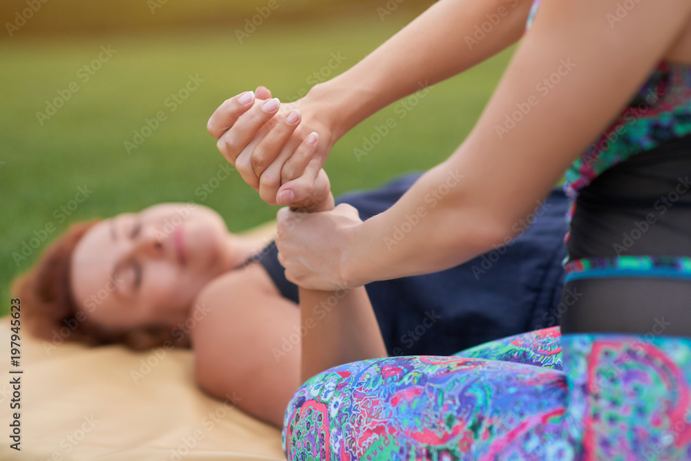 Naklejka premium Hands thai massage and relaxing. Caucasian women practising thai massage.