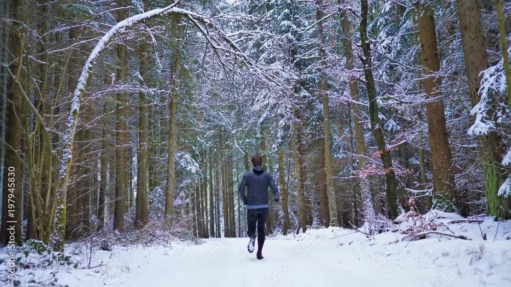 Runner with snow in the forest filmed with drone Runner with snow in the forest filmed with drone