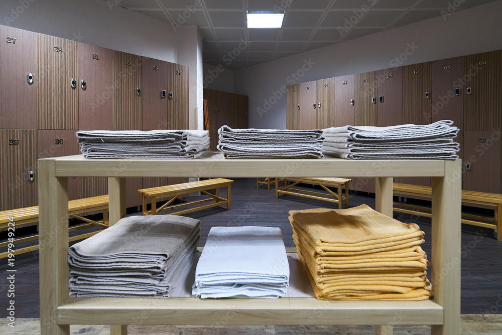 Clean towels shelf in a locker room with wooden benches in luxury