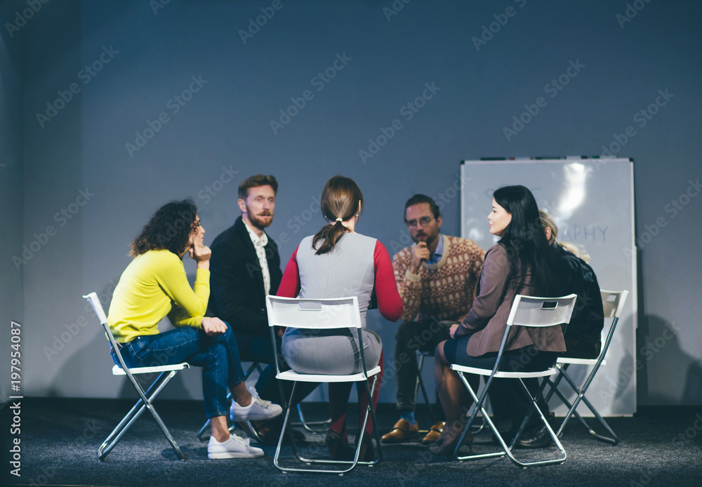 People sitting in circle in room. Having advice from therapist. Toned concept. People sitting in circle in room. Having advice from therapist. Toned concept.