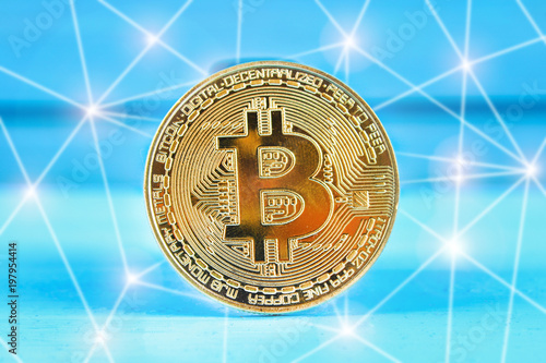 Gold coin crypto currency bitcoin on a blue table. photo