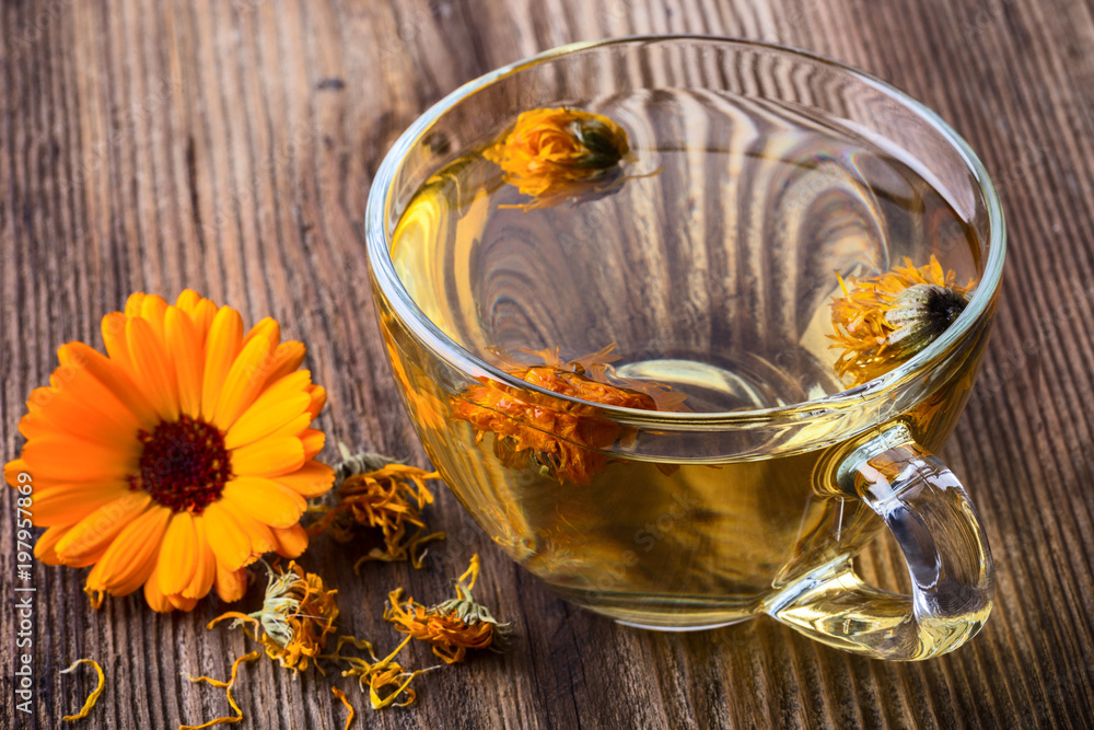 Calendula (Marigold) herbal tea in a transparent glass mug Calendula (Marigold) herbal tea in a transparent glass mug