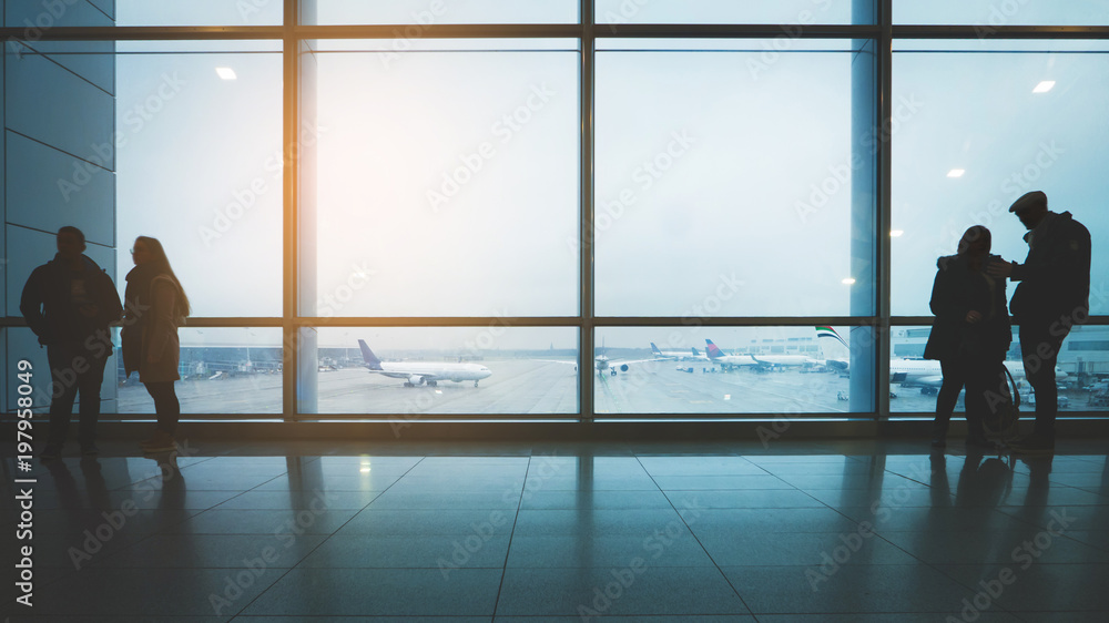 Young and elderly couple talking at the airport terminal. Sun flare effect Young and elderly couple talking at the airport terminal. Sun flare effect