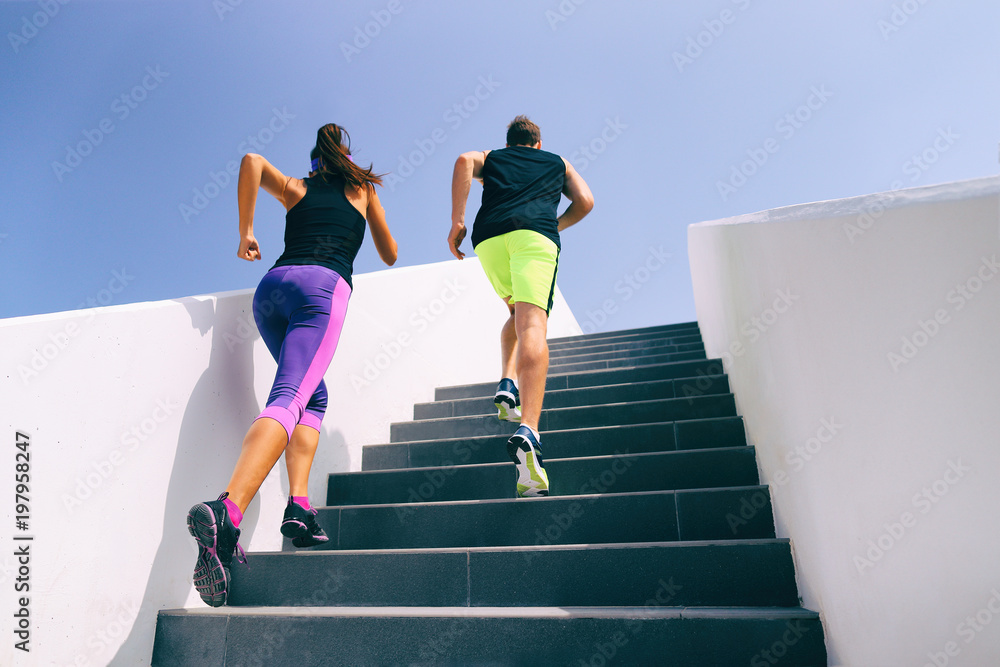 Stairs runners running up staircase training hiit workout. Couple