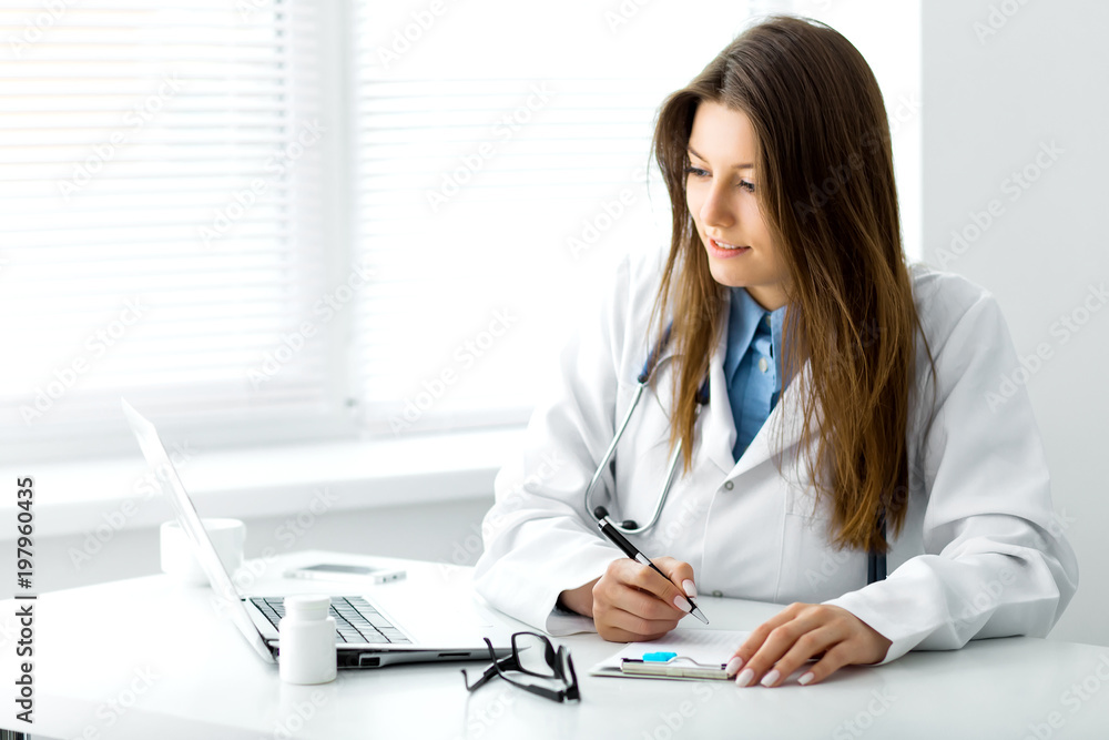 Doctor makes notes in a notebook sitting in the office Doctor makes notes in a notebook sitting in the office