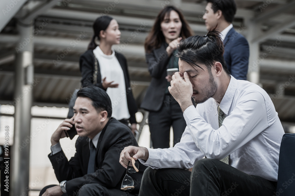 Businesspeople Gossiping Behind Stressed business man. Businesspeople Gossiping Behind Stressed business man.