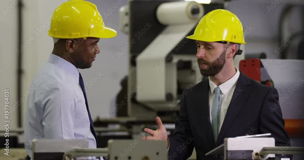 Warehouse managers discuss their business while on a digital tablet in slow motion. Warehouse managers discuss their business while on a digital tablet in slow motion.