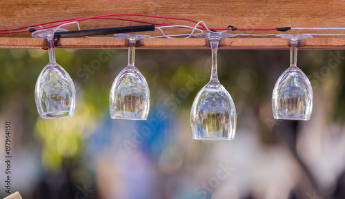 Wine glasses hanging on the planks. © murmakova