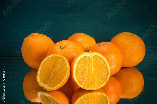frische Orangen nebeneinander mit aufgeschnittener Orange grüner Hintergrund
