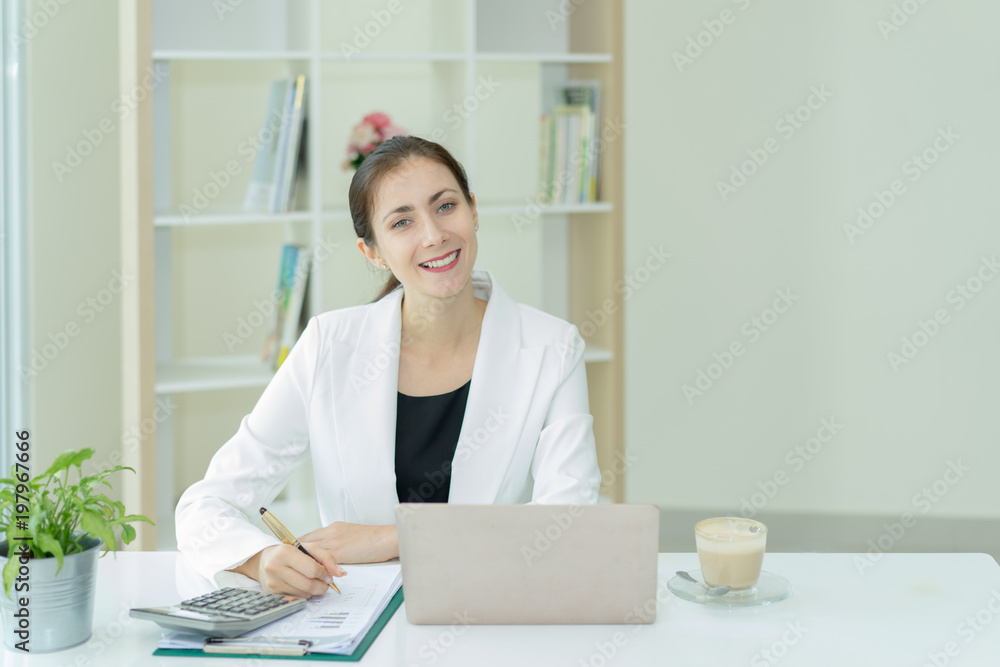 Portrait attractive businesswoman at office.young woman working in office with laptop,calculator and graph business Portrait attractive businesswoman at office.young woman working in office with laptop,calculator and graph business