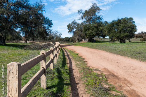 A wooden fence lines a walking trail at Ramona Grasslands Preserve in San Diego  California.