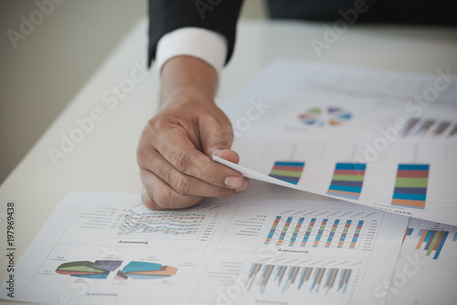 Hand of Businessman working on Data Charts,document at office desk. analyzing brainstorming, meeting concept..