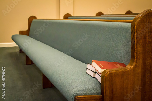Empty pews with stacked books photo