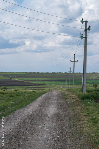 A road with electricity pillars on the edge.