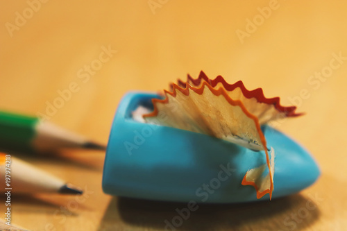 a shaving from pencils  a sharpener of pencils and pencils on a wooden background...